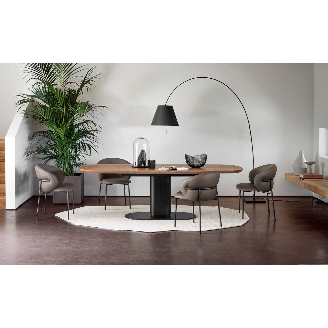 Modern dining area with a oval table, chairs, and decorative elements.