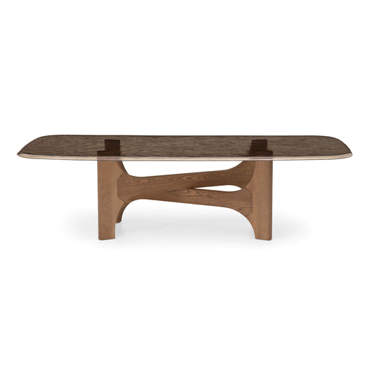 A modern rectangular coffee table with a dark brown wood grain top and a sculptural, curved wooden base, shown against a plain white background.