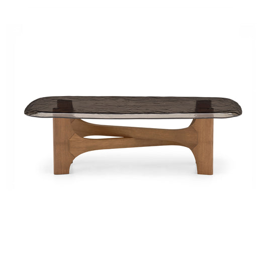 A modern coffee table with a dark textured glass top and a sculptural wooden base, shown against a plain white background.